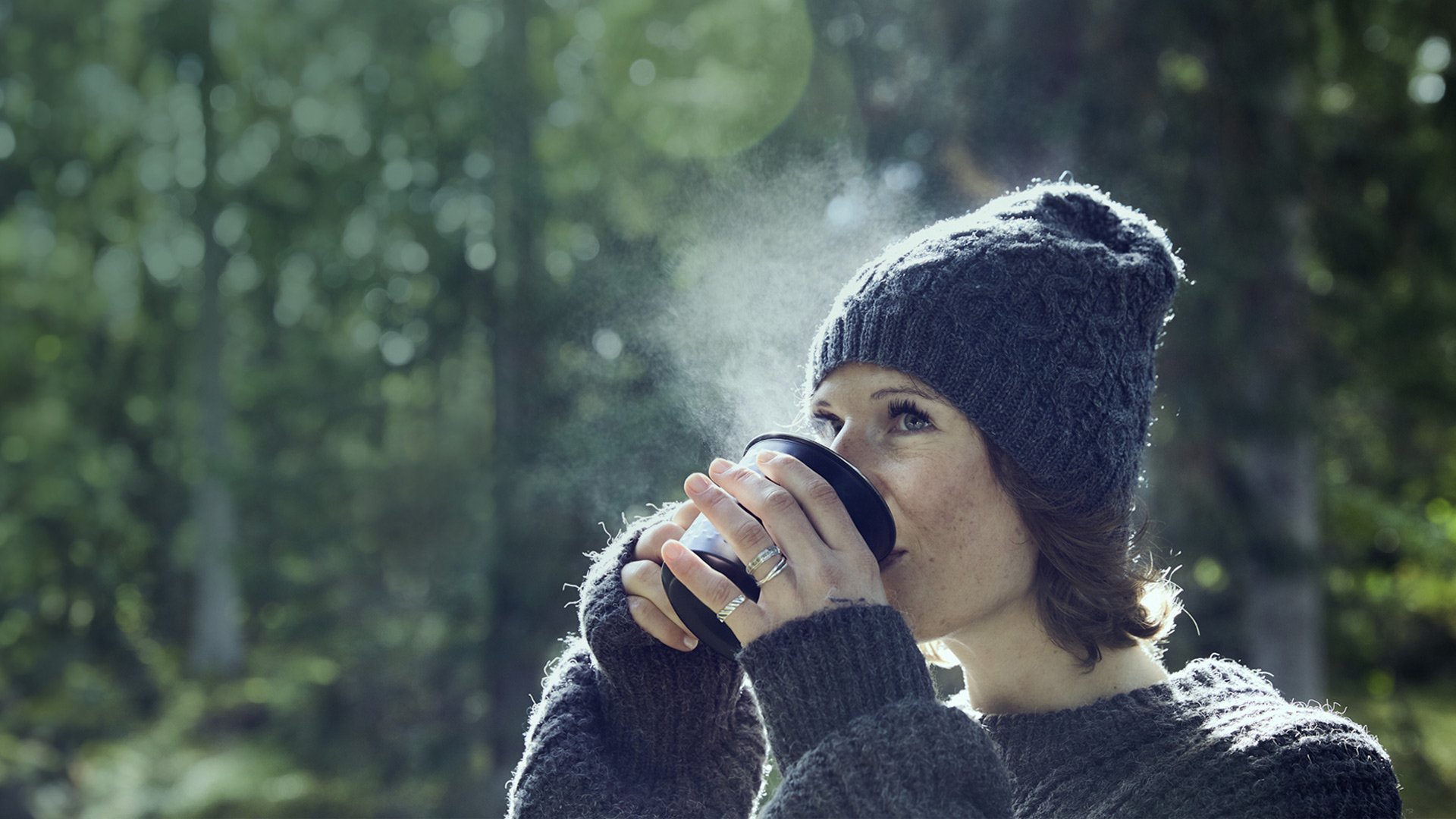 Kvinde, der har brystkræft med spredning, drikker kaffe i skoven. Illustrationsfoto