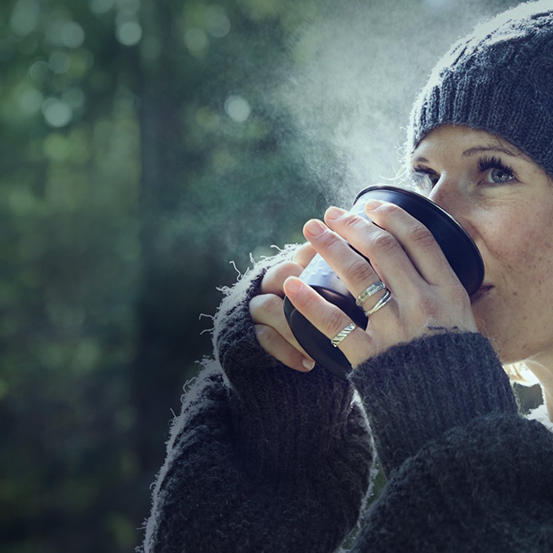 Kvinde, der har brystkræft med spredning, drikker kaffe i skoven. Illustrationsfoto