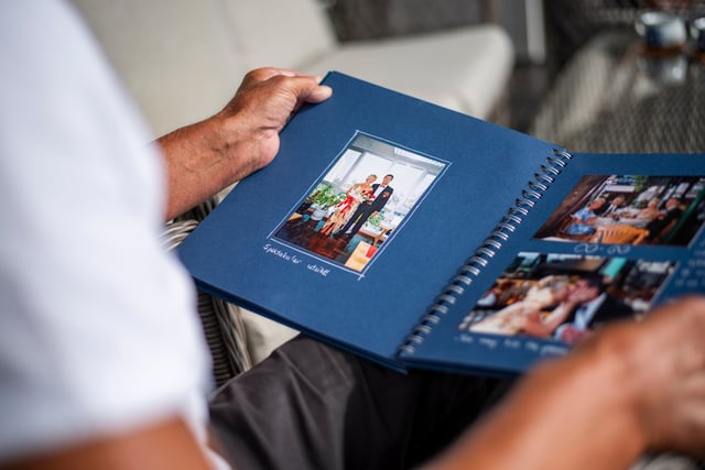Nærbillede af et bryllupsfoto i et fotoalbum. Marit Haavimb er iført en lys kjole med blomstermotiv, og Stein Tore er iført sort smoking.