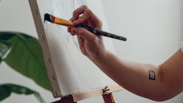 Nærbillede af hånd der maler på et lærred for at få et frirum fra tankemylder ved metastatisk brystkræft. Illustrationsfoto