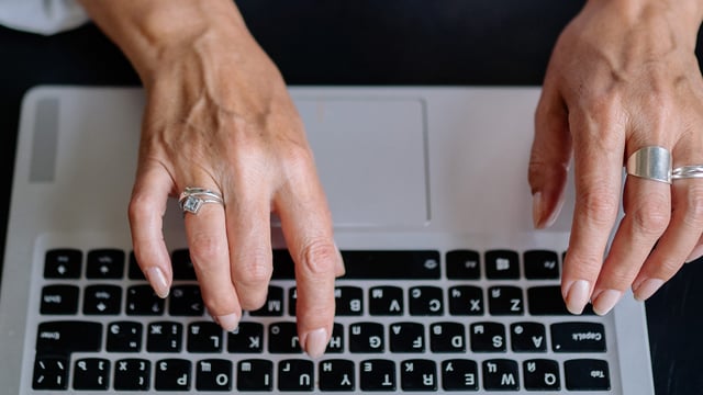 Hænder skriver på en bærbar computer. Illustrationsfoto